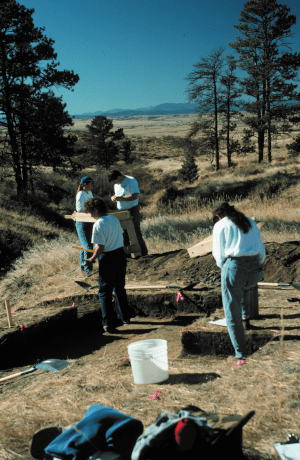 Archaeologists in the field working at a site in Douglas County Colorado. The archaeologists are screening for artifacts.